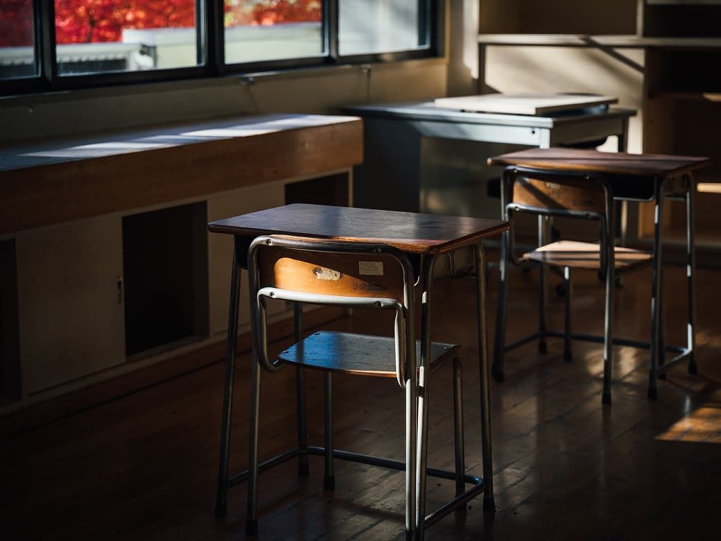 教室の机と椅子に差し込む秋の光